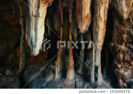Inside an underground cave with rock stalagmites and stalactites forming from the floor and ceiling 103000478