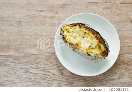 baking Japanese yam stuffing sweet corn seed with cheese in foil on plate 103001521
