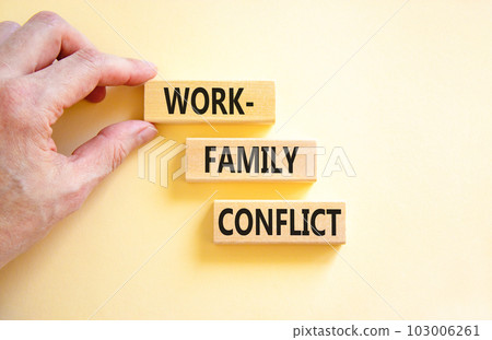 Work-family conflict symbol. Concept words Work-family conflict on wooden block on a beautiful white table white background. Businessman hand. Business work-family conflict concept. Copy space. 103006261