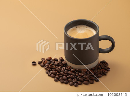 Coffee beans with cup of hot creamy black coffee on beige board Coffee beans with cup of hot creamy black coffee on beige board 103008543