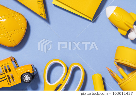Assorted office and school yellow stationery on lilac blue. copy space for back to school or education craft office work concept. Bright Yellow school bus, rocket. Achievement and success. 103011437