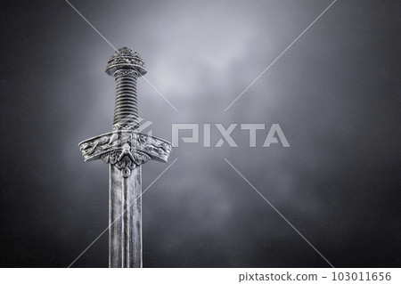 Medieval sword over dark misty background 103011656