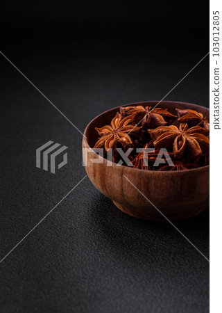 Star shaped spice star anise in a wooden round bowl Star shaped spice star anise in a wooden round bowl 103012805