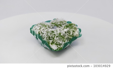 "Klepon" is a traditional food from Indonesia, snack of sweet rice cake balls filled with molten palm sugar and coated in grated coconut. "Klepon" is a traditional food from Indonesia, snack of sweet rice cake balls filled with molten palm sugar and coated in grated coconut. 103014929