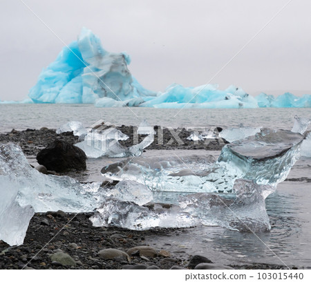 Blue Icebergs in Ocean Water. Glacier Ice Drift at Calm Water. Pure Ice Chunks from Melting Glacier. Icy Winter Landscape. Foggy Weather in Iceland. 103015440