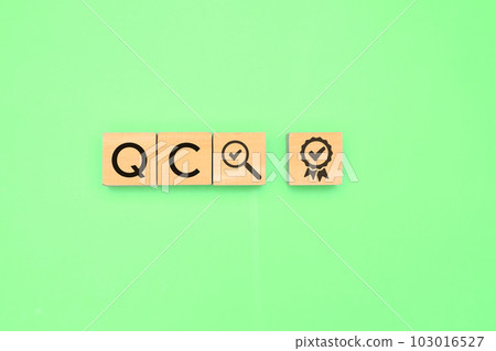 Quality control text icon on wooden cube with green background 103016527