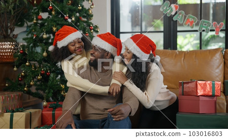 Happy family enjoying with Christmas trees in the living room Happy family enjoying with Christmas trees in the living room 103016803