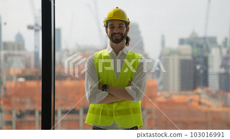Portrait of confident engineer with safety helmet and vest on building site Portrait of confident engineer with safety helmet and vest on building site 103016991