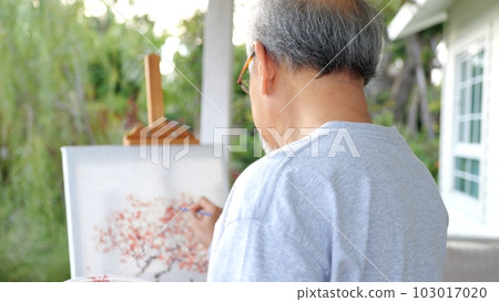 Senior holding color paint drawing on white paper Senior holding color paint drawing on white paper 103017020