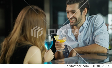 Couple of handsome man and beautiful woman drinking cocktails in luxury bar 103017164