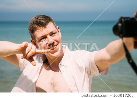 Handsome man taking selfie with beautiful beach Handsome man taking selfie with beautiful beach 103017203