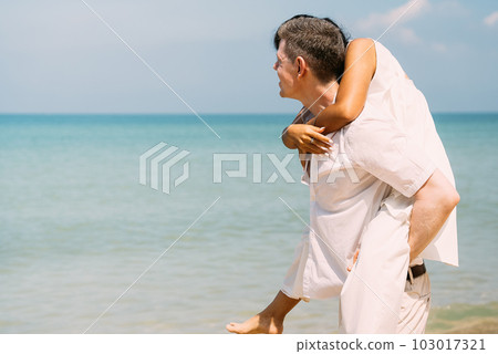 Man and woman enjoying with honeymoon trip at beach 103017321