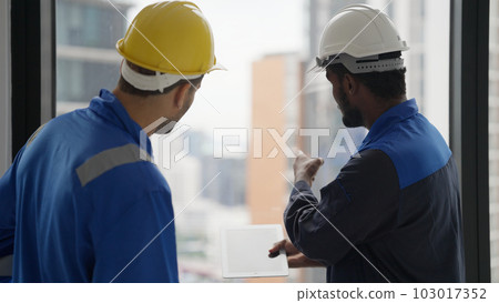 Contractor with safety helmet brainstorming with electrician technician Contractor with safety helmet brainstorming with electrician technician 103017352