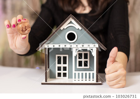 Businesswoman reflects on investing profits in bitcoin or real estate Businesswoman reflects on investing profits in bitcoin or real estate 103026731