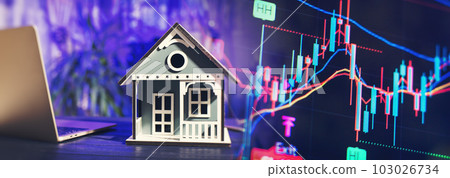 concept of buying and selling real estate. A man with a model of a house on the background of the forex chart. 103026734