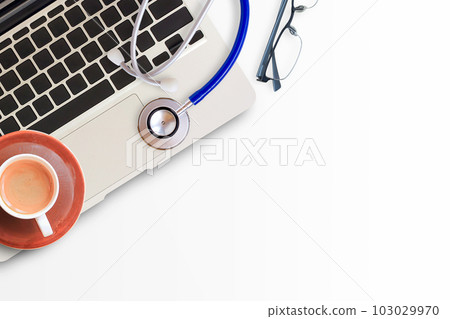 Blue stethoscope with cup of coffee,glasses and laptop computer on white office table Blue stethoscope with cup of coffee,glasses and laptop computer on white office table 103029970