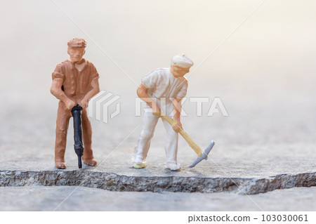 Figures construction worker, is working on a cracked area Figures construction worker, is working on a cracked area 103030061