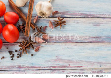 Close up garlic,red tomato,spices and herbs on a wooden table background 103030065