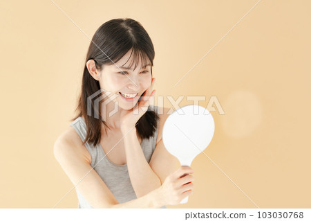 Woman checking with a hand mirror beauty Woman checking with a hand mirror beauty 103030768