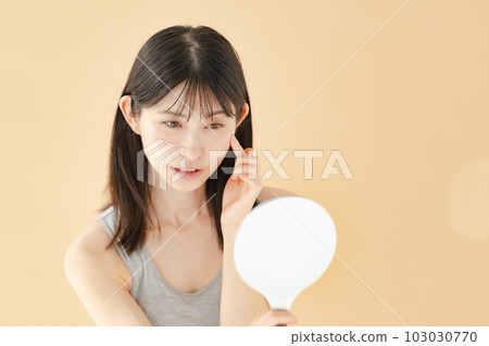 Woman checking with a hand mirror beauty 103030770