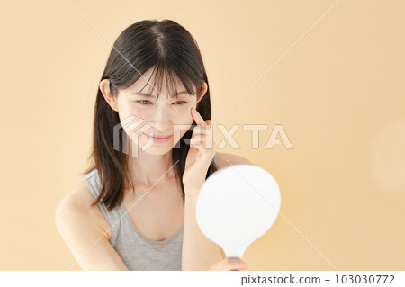 Woman checking with a hand mirror beauty 103030772