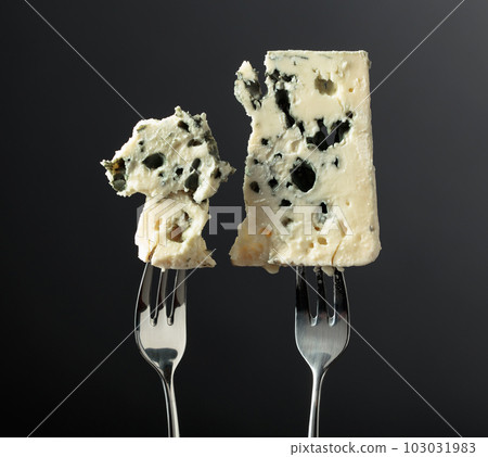 Blue cheese slices on forks. Blue cheese slices on forks. 103031983