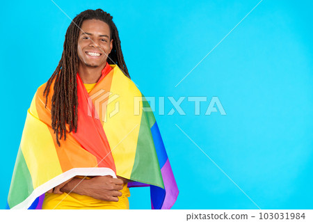 Happy latin man with dreadlocks wrapped with a lgbt flag Happy latin man with dreadlocks wrapped with a lgbt flag 103031984