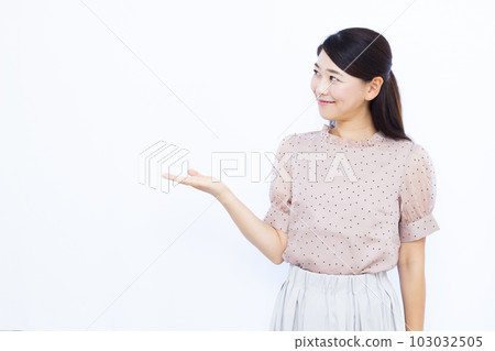 A woman in her thirties making an introduction in front of a white background A woman in her thirties making an introduction in front of a white background 103032505