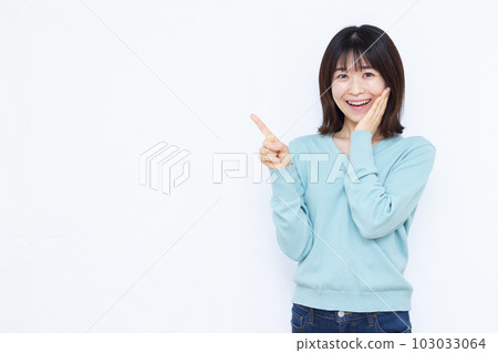 A woman in her thirties who raises her index finger in front of a white background A woman in her thirties who raises her index finger in front of a white background 103033064