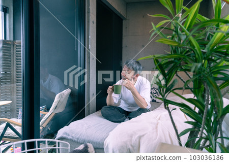middle aged man drinking coffee on bed 103036186
