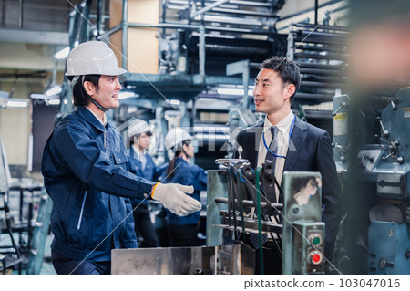 售貨員和工人在機器前交談 103047016