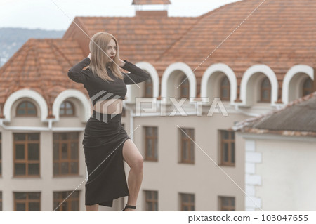 Sexy woman walking along on old architecture background. Stylish young woman in black clothes on the street Sexy woman walking along on old architecture background. Stylish young woman in black clothes on the street 103047655
