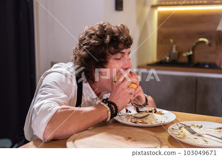 Handsome hungry man enjoying in delicious burger - fastfood and junk food concept 103049671