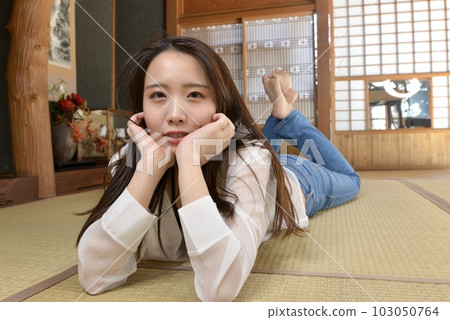 一位身穿牛仔服的年輕女子在一座古老民居的日式房間裡擺姿勢 一位身穿牛仔服的年輕女子在一座古老民居的日式房間裡擺姿勢 103050764