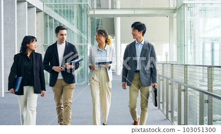 Multinational business group walking through lobby 103051300