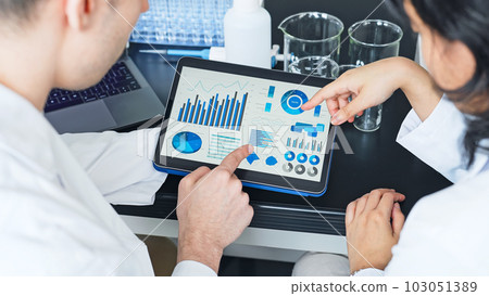 研究人員在實驗室中查看平板電腦上的數據 103051389