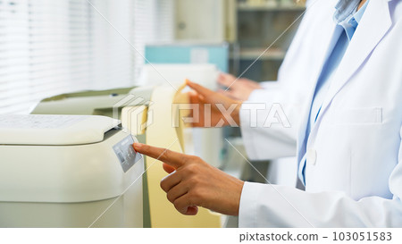 Researcher using experimental equipment Researcher using experimental equipment 103051583