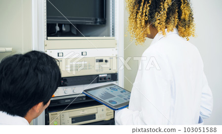 Multinational group operating electronic devices while looking at tablet Multinational group operating electronic devices while looking at tablet 103051588