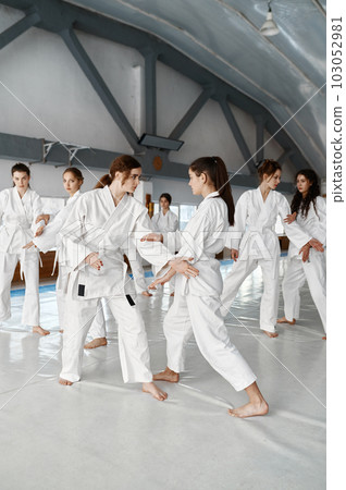 Teenage girls practicing new moves during aikido class 103052981