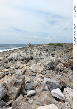 A high tower of flat stones stands on the seashore in cloudy weather 103052989