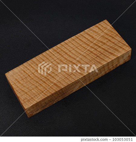 Sawn timber of rare wood with a beautiful pattern for crafts on black background 103053051