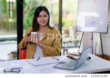 Concept of business office woman working,Businesswoman smile while working about her invesment plan with analyzing document and business investment graph data by using laptop on desk in workstation. Concept of business office woman working,Businesswoman smile while working about her invesment plan with analyzing document and business investment graph data by using laptop on desk in workstation. 103053230