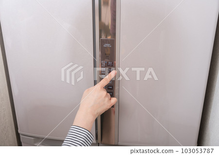 [Housewife pressing the temperature control button in the refrigerator] 103053787