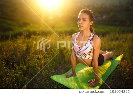Healthy woman lifestyle balanced practicing meditate and energy yoga. The girl sitting on the slope 103054235