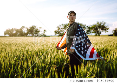 Man hold waving american USA flag. Patriot raise national american flag. Independence Day, 4th July. Man hold waving american USA flag. Patriot raise national american flag. Independence Day, 4th July. 103054690