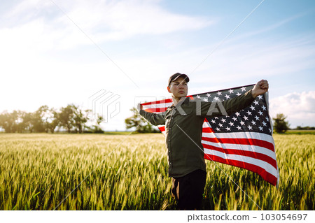 Man hold waving american USA flag. Patriot raise national american flag. Independence Day, 4th July. 103054697