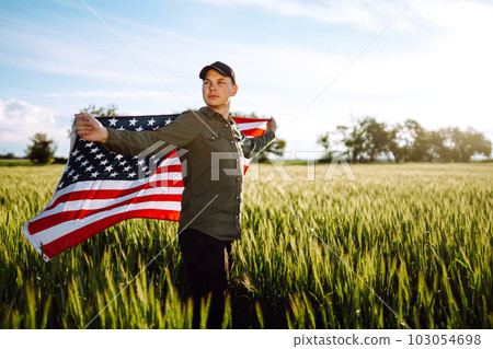 Man hold waving american USA flag. Patriot raise national american flag. Independence Day, 4th July. 103054698