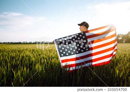 Man hold waving american USA flag. Patriot raise national american flag. Independence Day, 4th July. 103054700