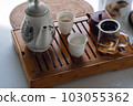 the concept of an Asian tea set with a white tea set of cups and a teapot with fresh tea on a wooden tray 103055362
