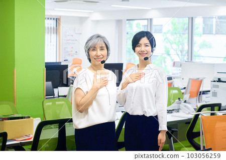 Female operator with headset working in the office Female operator with headset working in the office 103056259